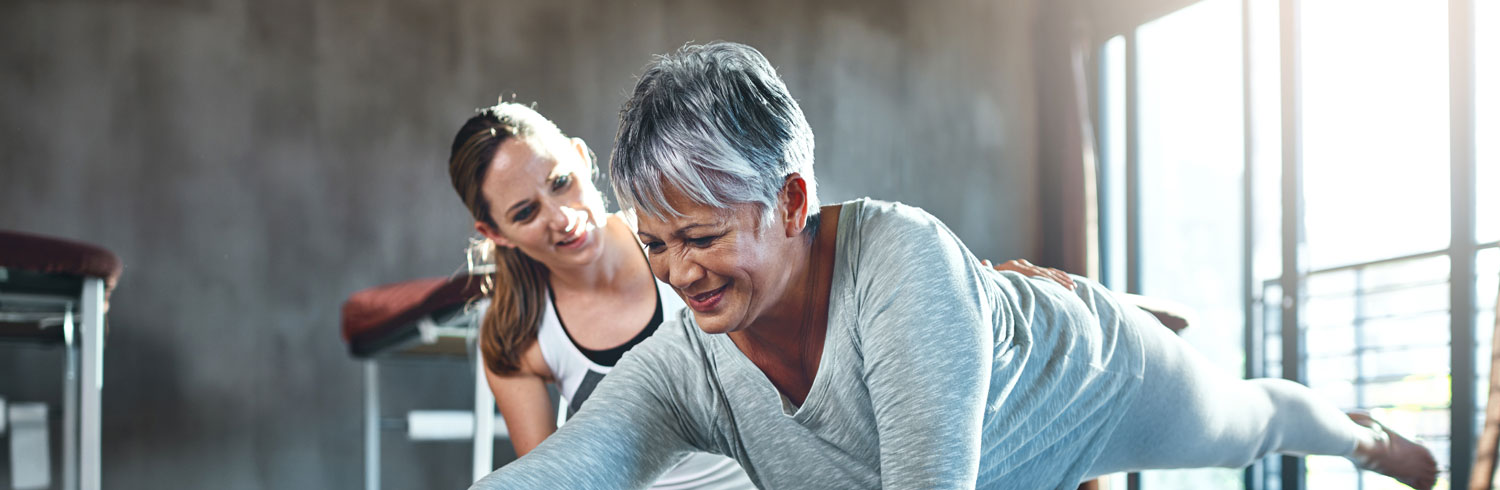 Two women engaging in a fitness training session indoors.